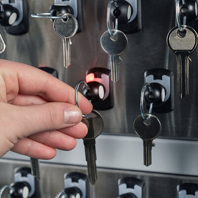 Schlüsselentnahme Person entnimmt einen Schlüssel aus einem elektronischen Schlüsselschrank
