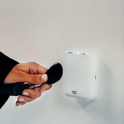 PRx 6 Access control reader white Person holds transponder in front of access control reader