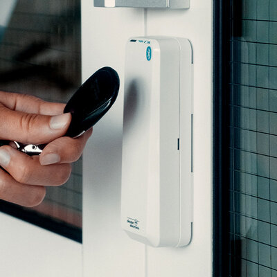 PRx 3 Access control reader white Person holds transponder in front of access control reader